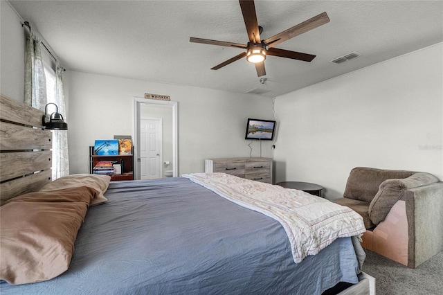 bedroom with visible vents, ceiling fan, carpet, and a textured ceiling