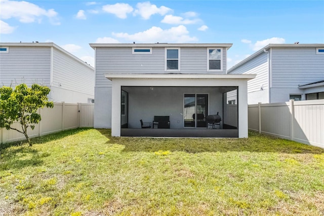 rear view of property featuring a yard, a fenced backyard, a sunroom, and stucco siding