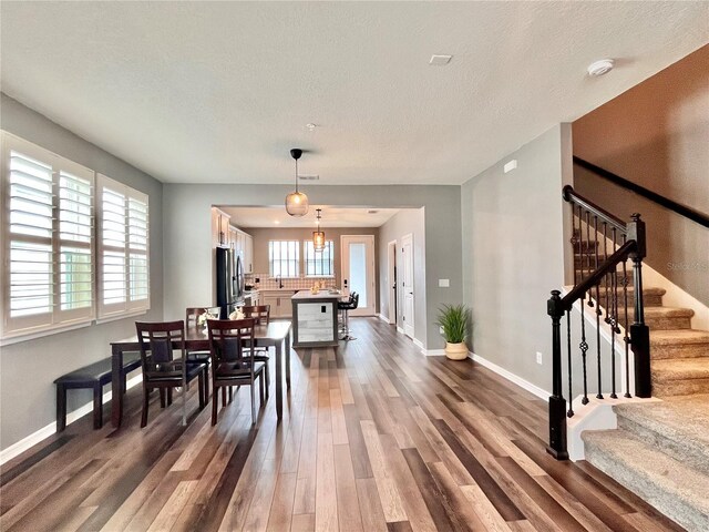 dining room featuring baseboards, stairway, a textured ceiling, and dark wood-style flooring