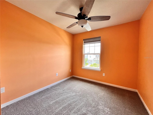 spare room with a ceiling fan, carpet floors, and baseboards