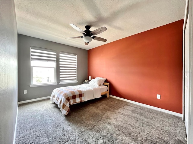 bedroom with a textured ceiling, baseboards, a ceiling fan, and carpet floors
