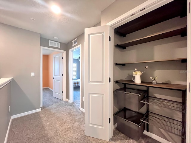 interior space featuring visible vents, carpet flooring, and baseboards