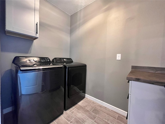 laundry room with cabinet space, independent washer and dryer, baseboards, wood finish floors, and a textured ceiling