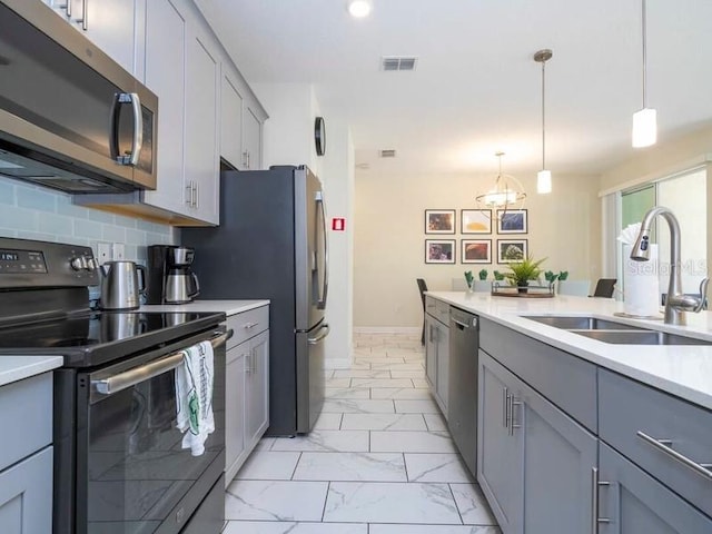 428 Ocean Course Ave, Davenport, FL 33896 - kitchen with appliances with stainless steel finishes, a sink, light marble finish floors, gray cabinets, and light countertops