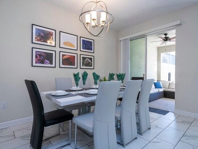 428 Ocean Course Ave, Davenport, FL 33896 - dining room with light marble finish floors, a chandelier, baseboards, and a ceiling fan