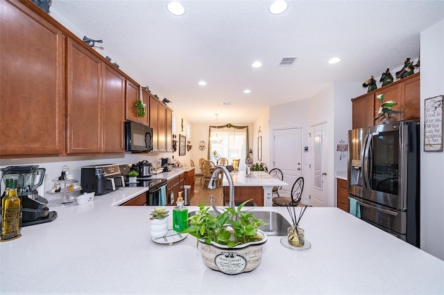 2289 Aloe Aly, Apopka, FL 32703 - kitchen with black microwave, light countertops, stainless steel refrigerator with ice dispenser, visible vents, and recessed lighting