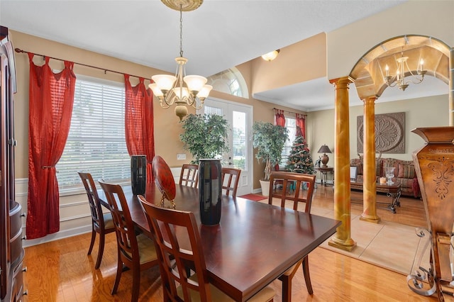 920 Nola Dr, Ocoee, FL 34761 - dining room featuring a chandelier, light wood-style flooring, and decorative columns