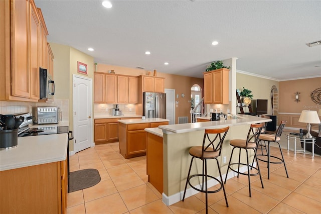 920 Nola Dr, Ocoee, FL 34761 - kitchen featuring black appliances, a peninsula, light tile patterned flooring, a kitchen island, and tasteful backsplash