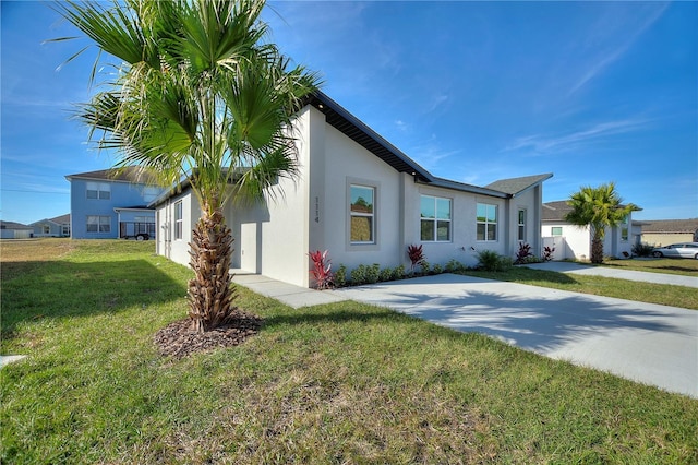 view of side of property with a lawn and stucco siding