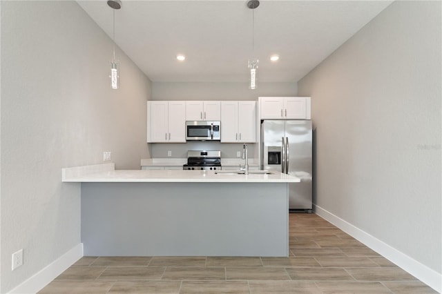 kitchen with light countertops, a sink, hanging light fixtures, stainless steel appliances, and white cabinets