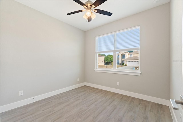 empty room with a ceiling fan, baseboards, and light wood-style floors