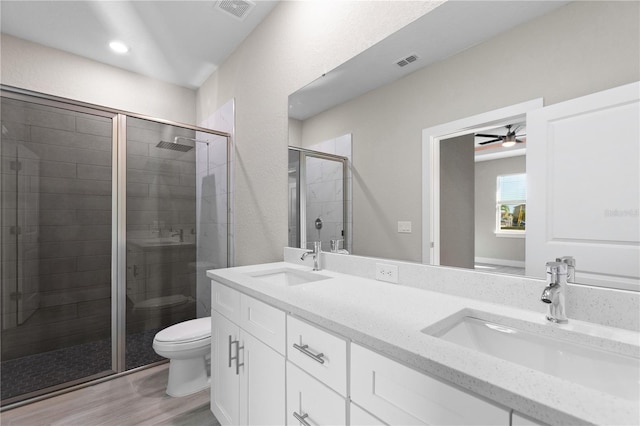 full bathroom featuring toilet, a sink, a shower stall, and visible vents