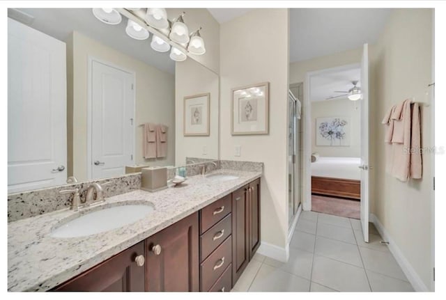 bathroom with a shower stall, double vanity, tile patterned flooring, and a sink