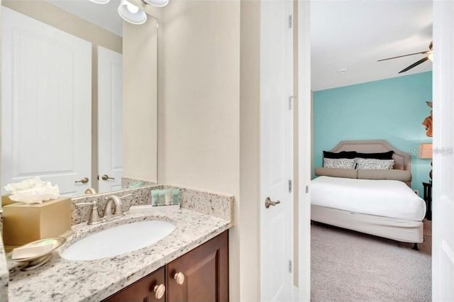 ensuite bathroom with connected bathroom, vanity, and a ceiling fan
