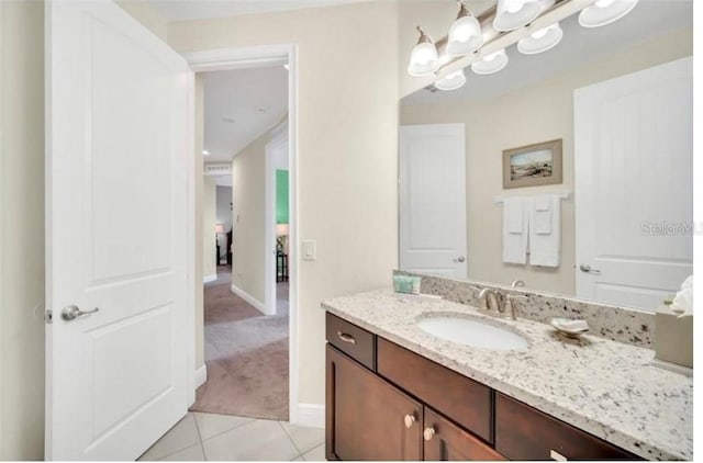bathroom with tile patterned floors, vanity, baseboards, and a chandelier