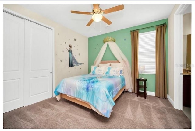 carpeted bedroom featuring a closet, baseboards, and a ceiling fan