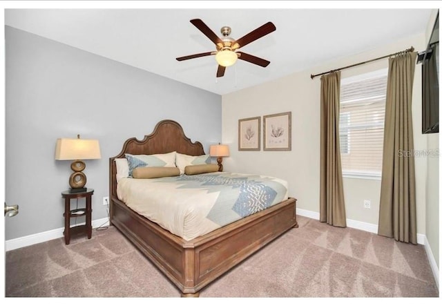carpeted bedroom with a ceiling fan and baseboards