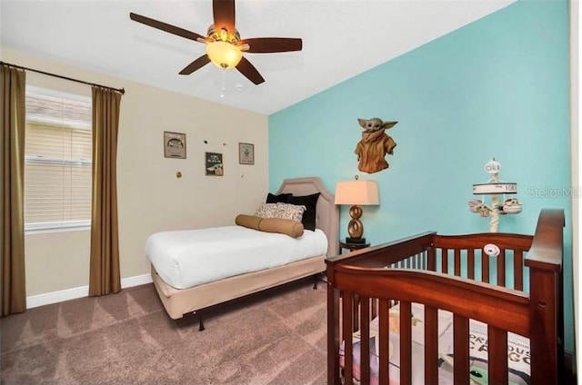carpeted bedroom featuring baseboards and a ceiling fan