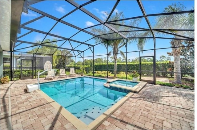 view of swimming pool with a patio, a pool with connected hot tub, and glass enclosure