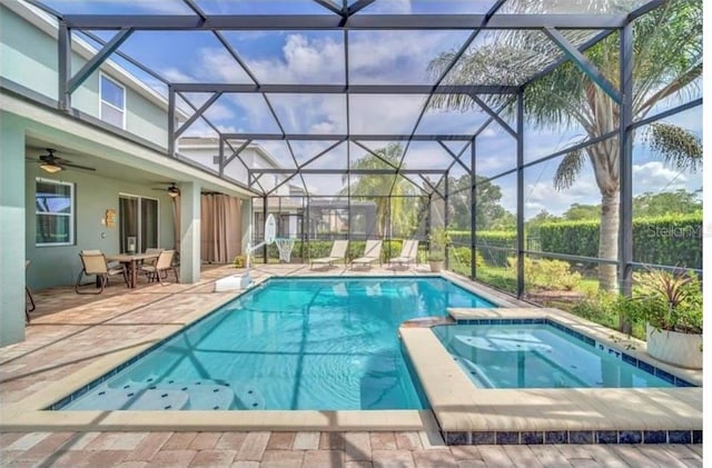 view of swimming pool with a pool with connected hot tub, glass enclosure, ceiling fan, and a patio