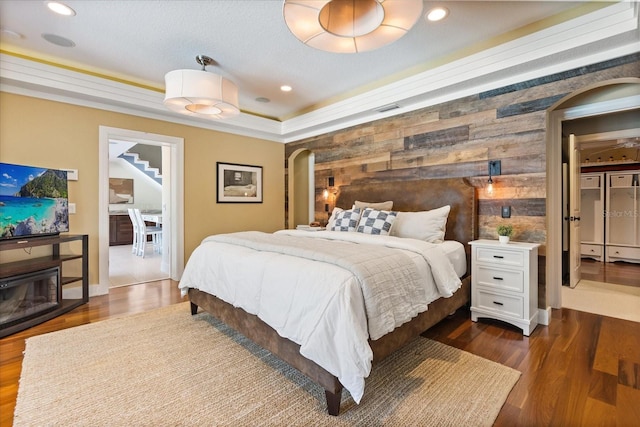 7849 Georgeann St, Winter Park, FL 32792 - bedroom with arched walkways, wood walls, dark wood-style flooring, an accent wall, and recessed lighting