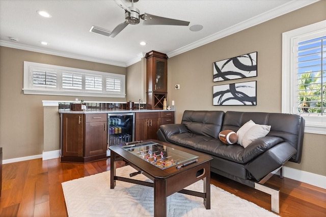 7849 Georgeann St, Winter Park, FL 32792 - living area with wine cooler, bar with sink, crown molding, dark wood-style floors, and baseboards