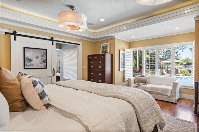 7849 Georgeann St, Winter Park, FL 32792 - bedroom with wood finished floors, crown molding, a barn door, baseboards, and recessed lighting