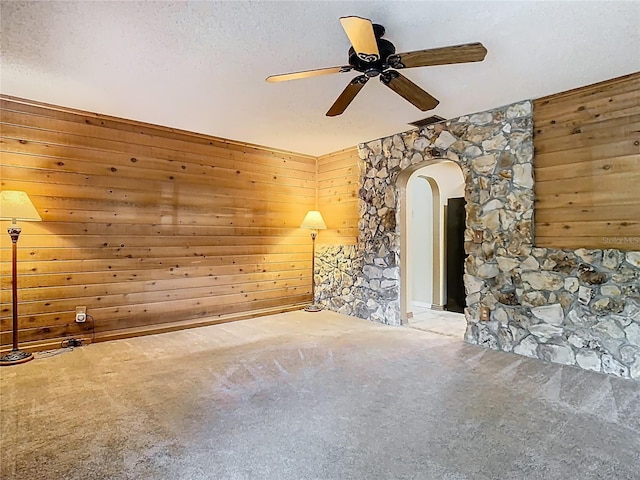 410 Sandspur Rd N, Maitland, FL 32751 - carpeted empty room with a textured ceiling, arched walkways, wooden walls, visible vents, and a ceiling fan