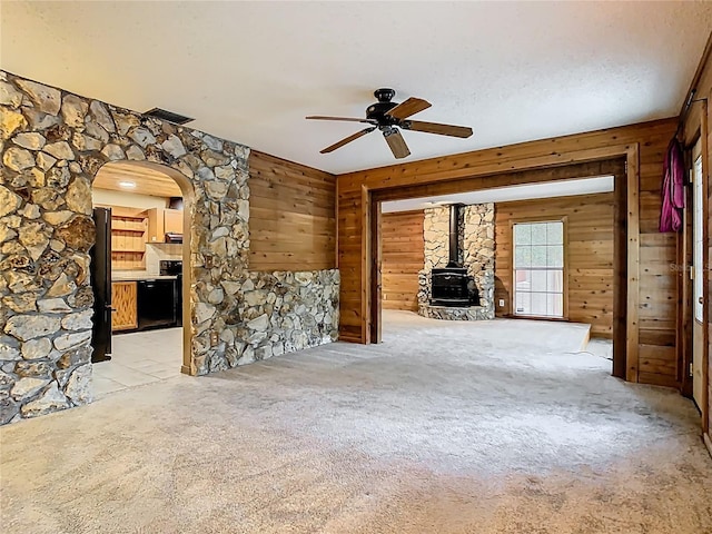 410 Sandspur Rd N, Maitland, FL 32751 - unfurnished living room featuring arched walkways, wood walls, and a wood stove