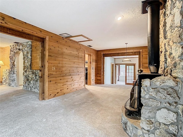 410 Sandspur Rd N, Maitland, FL 32751 - unfurnished living room with visible vents, wooden walls, a wood stove, and carpet flooring