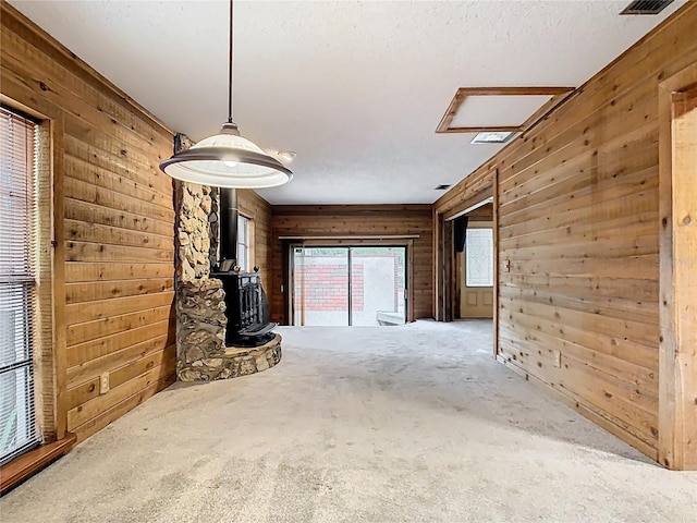 410 Sandspur Rd N, Maitland, FL 32751 - unfurnished living room featuring a wood stove and wooden walls