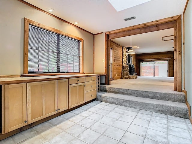 410 Sandspur Rd N, Maitland, FL 32751 - kitchen with visible vents, wooden walls, a skylight, hanging light fixtures, and light brown cabinetry