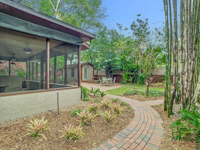 410 Sandspur Rd N, Maitland, FL 32751 - view of yard featuring a fenced backyard, a sunroom, a patio area, and an outbuilding