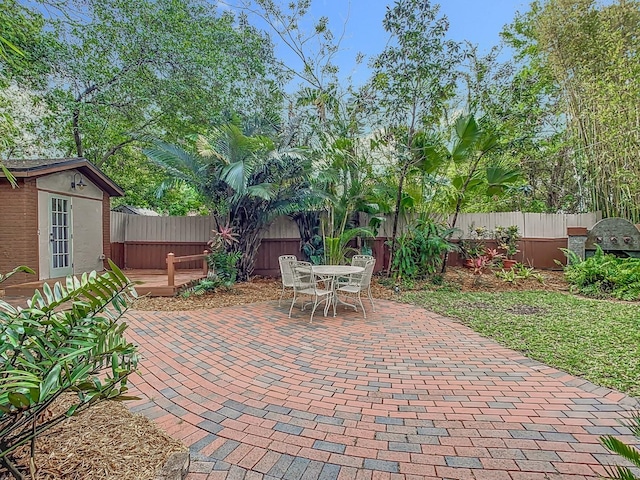 410 Sandspur Rd N, Maitland, FL 32751 - view of patio / terrace with a fenced backyard, outdoor dining space, and an outbuilding