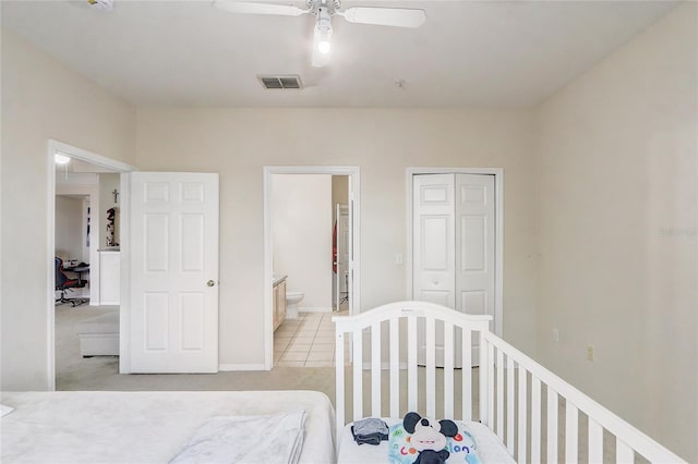 bedroom featuring a closet, light tile patterned floors, baseboards, visible vents, and ceiling fan