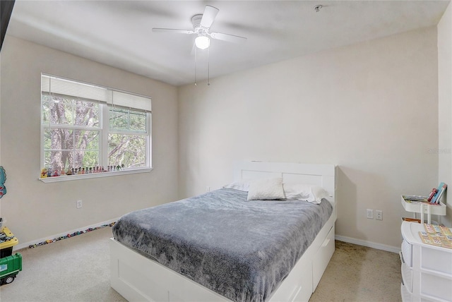 bedroom with a ceiling fan, light carpet, and baseboards