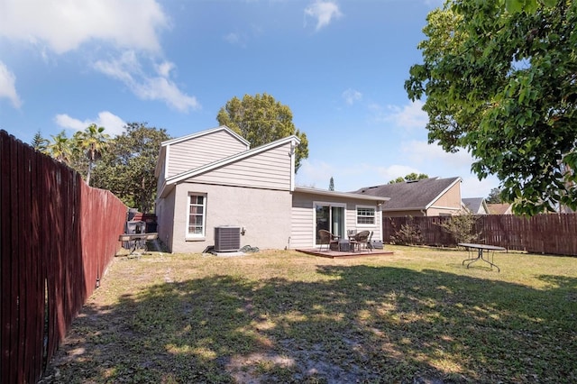 10724 Harkwood Blvd, Orlando, FL 32817 - back of house featuring central AC, a fenced backyard, stucco siding, a lawn, and a patio