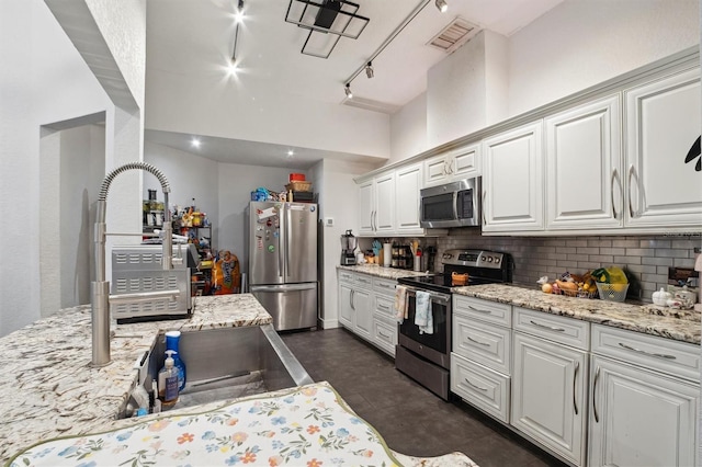10724 Harkwood Blvd, Orlando, FL 32817 - kitchen with tasteful backsplash, visible vents, white cabinetry, stainless steel appliances, and light stone counters