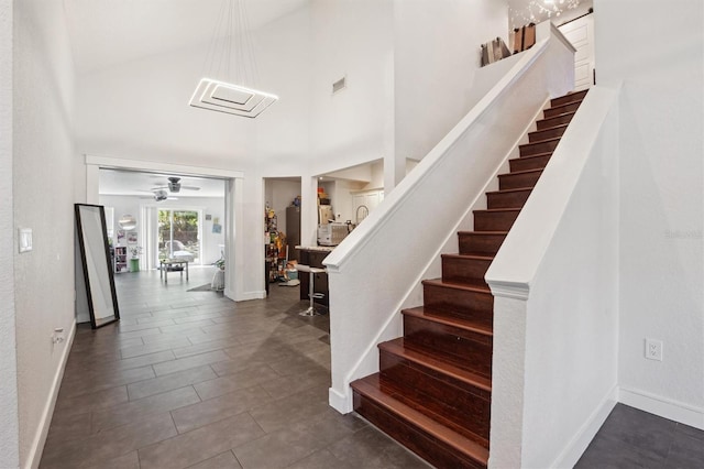 10724 Harkwood Blvd, Orlando, FL 32817 - stairway with baseboards, a towering ceiling, visible vents, and a ceiling fan