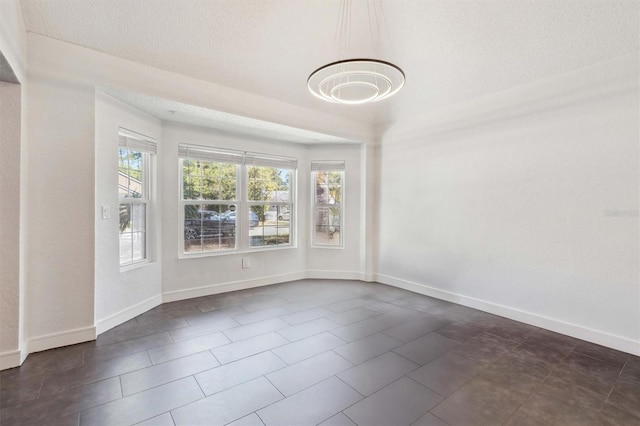 10724 Harkwood Blvd, Orlando, FL 32817 - spare room featuring baseboards, plenty of natural light, a chandelier, and a textured ceiling