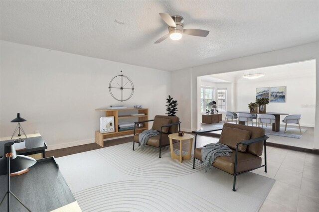 10724 Harkwood Blvd, Orlando, FL 32817 - living room featuring a textured ceiling, baseboards, and ceiling fan