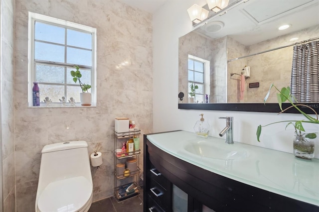 10724 Harkwood Blvd, Orlando, FL 32817 - bathroom featuring toilet, tile walls, a wealth of natural light, and vanity
