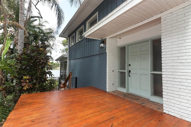 exterior space with brick siding, a wooden deck, and board and batten siding