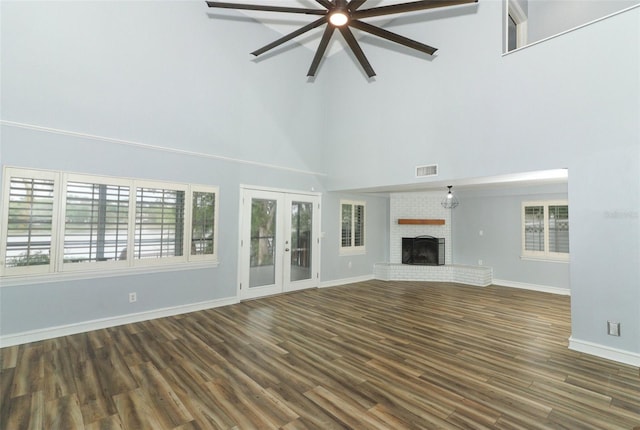 unfurnished living room featuring baseboards, a high ceiling, a ceiling fan, dark wood finished floors, and french doors