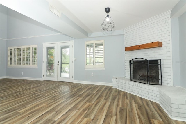 unfurnished living room with visible vents, baseboards, a fireplace, wood finished floors, and french doors