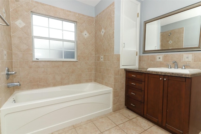 bathroom featuring tile patterned flooring, vanity, a bath, and tile walls