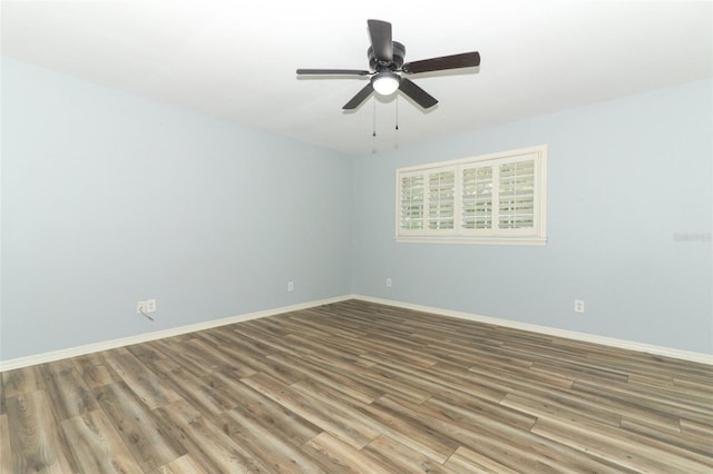spare room featuring baseboards, ceiling fan, and wood finished floors