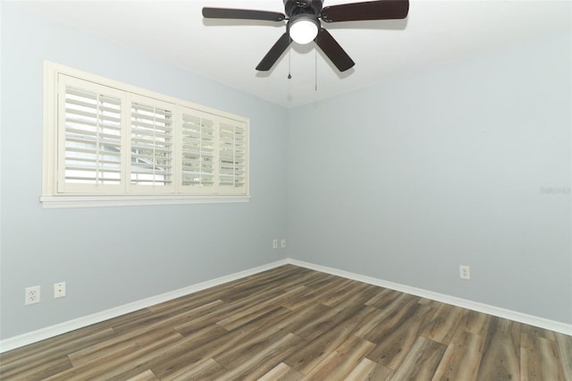 empty room featuring wood finished floors, baseboards, and a ceiling fan