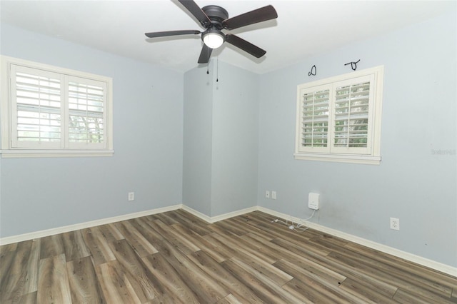 empty room with baseboards, a ceiling fan, wood finished floors, and a healthy amount of sunlight