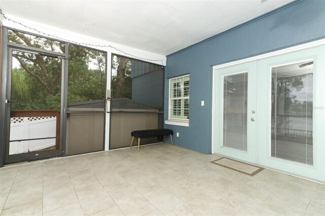 unfurnished sunroom featuring french doors and a hot tub